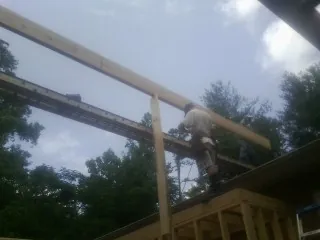 Carpenter setting a ridge beam over a new addition frame — Ice Dam Removal by Roofing Brothers in Kankakee