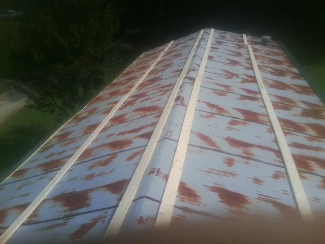 Rusted metal roof panels with new wood purlins before replacement — Storm Damage Roof Repair in Kankakee by Roofing Brothers