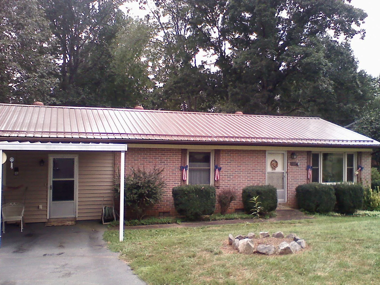 Bronze metal roof and carport on a brick ranch home — Roof Repair work by our crew in Kankakee